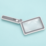 Oplaadbaar ledvergrootglas met rechthoekige lens en uitgeklapt handvat op een zacht turquoise achtergrond