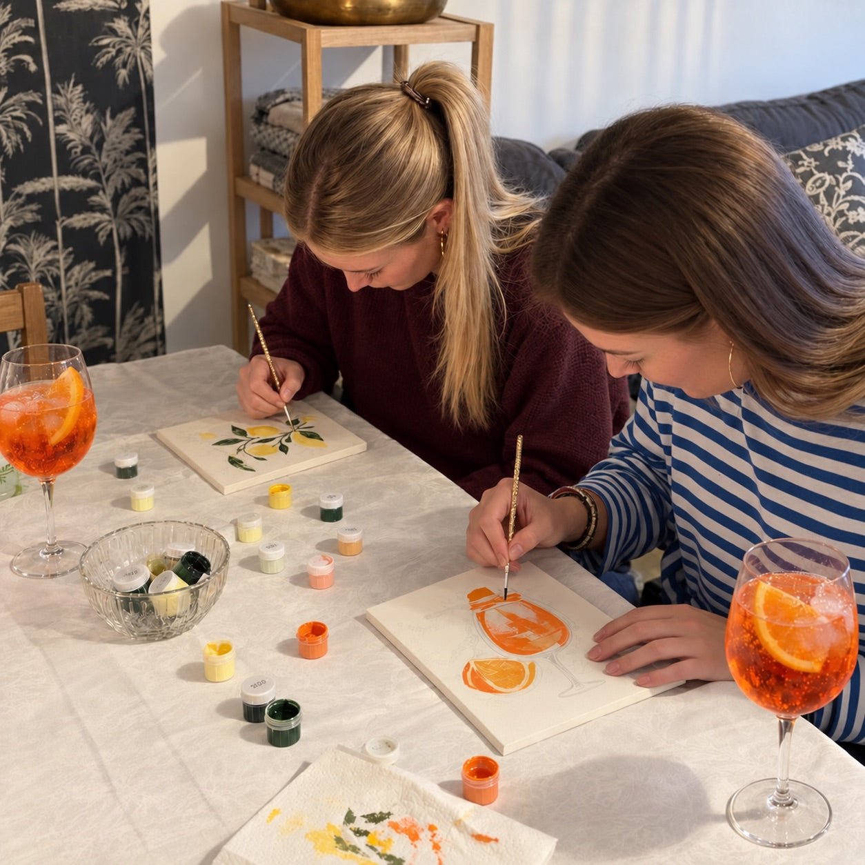 Twee makers schilderen fruitmotieven aan tafel